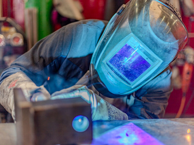 GEWA Maschinenbau & Fertigungstechnik GmbH Kleinheubach: Schweißer arbeitet mit Schutzhelm.